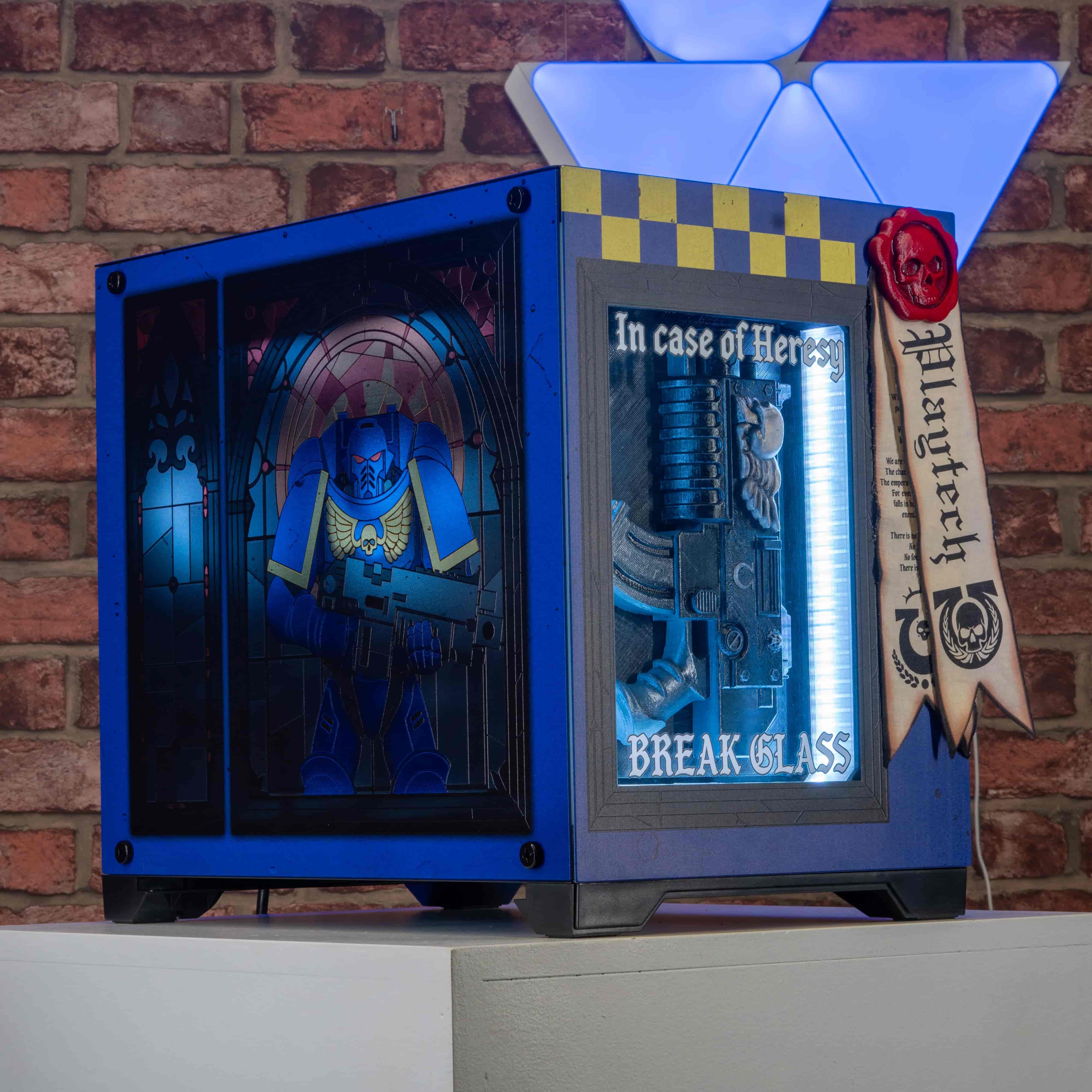 Blue and black warhammer themed case with a character inside, against a brick wall background.